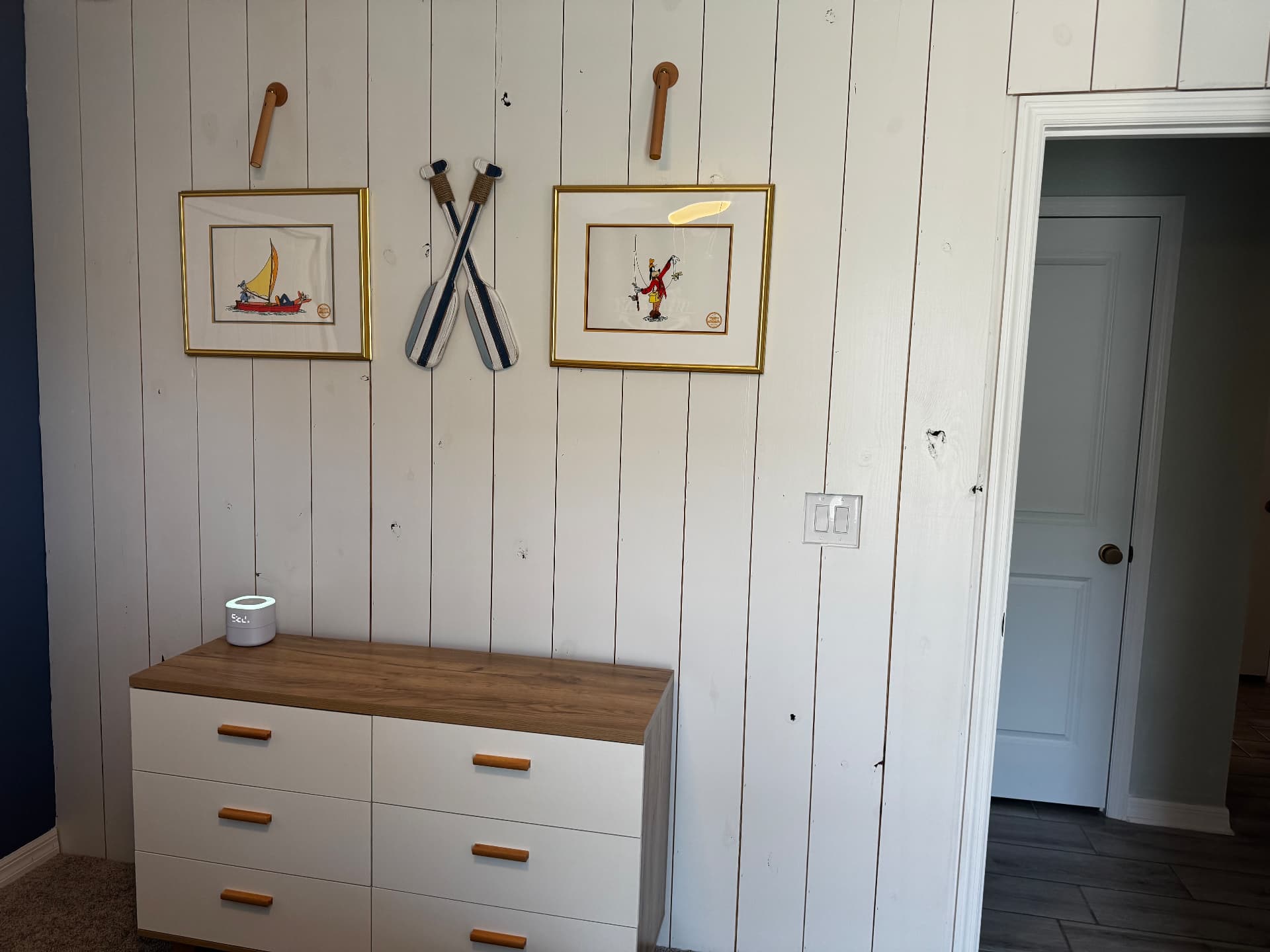 Styled wall with layered art and shelving in a Dora Wall Co. project